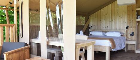 A wooden cabin with a bed, a table, and a chair.