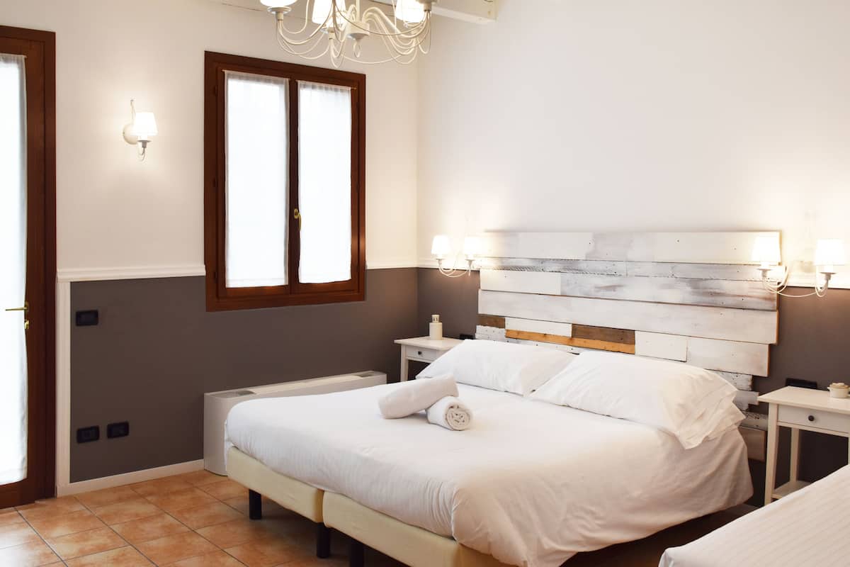 Une chambre à coucher avec un lit, des tables de chevet et une fenêtre.