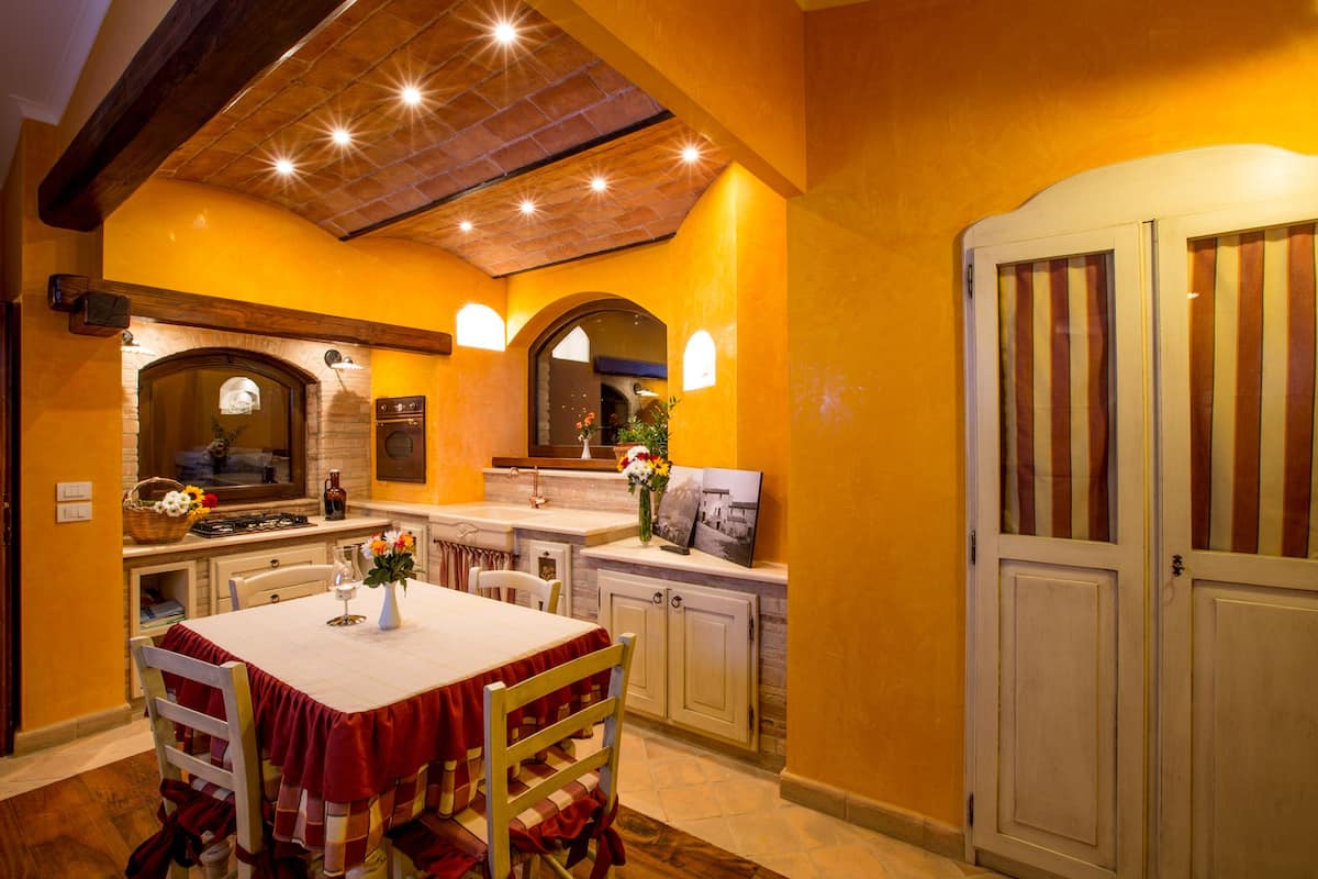 Una cocina con una mesa de comedor, sillas y un armario.