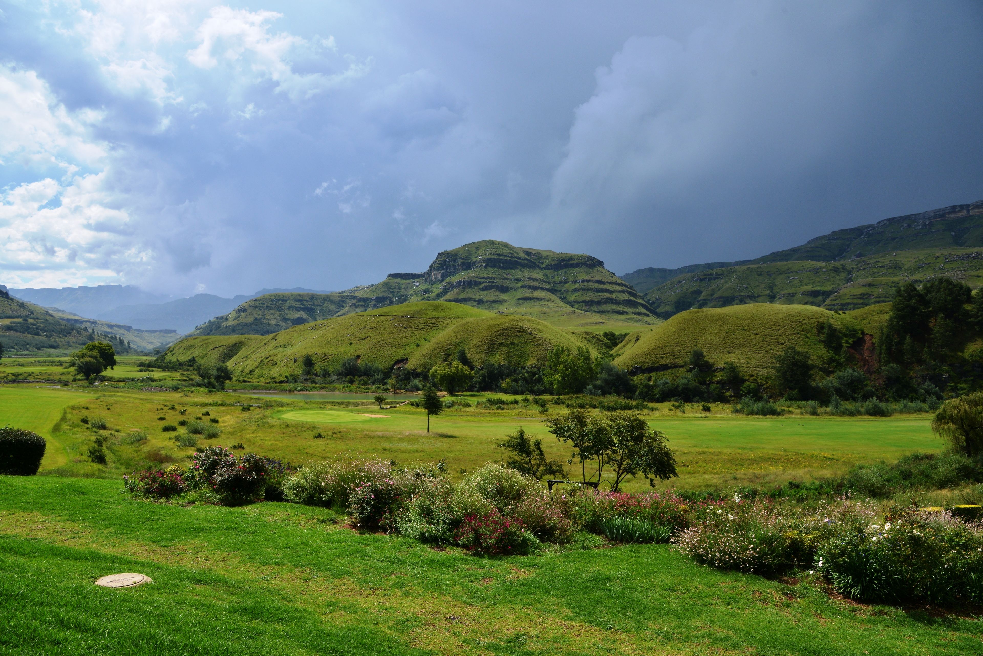 Un paisaje exuberante con colinas onduladas y un campo de golf.