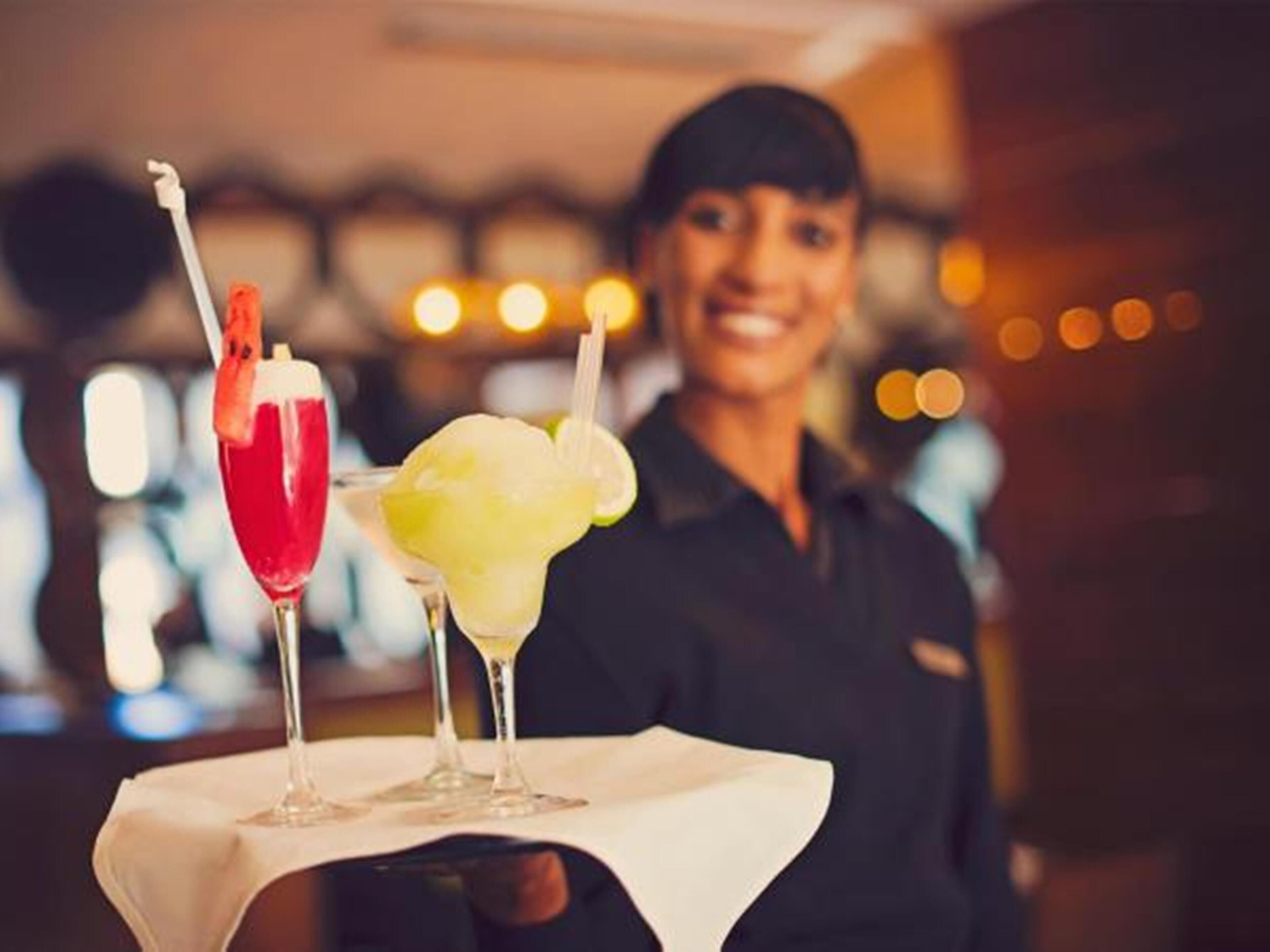 A bar area with two cocktails on a white tablecloth.