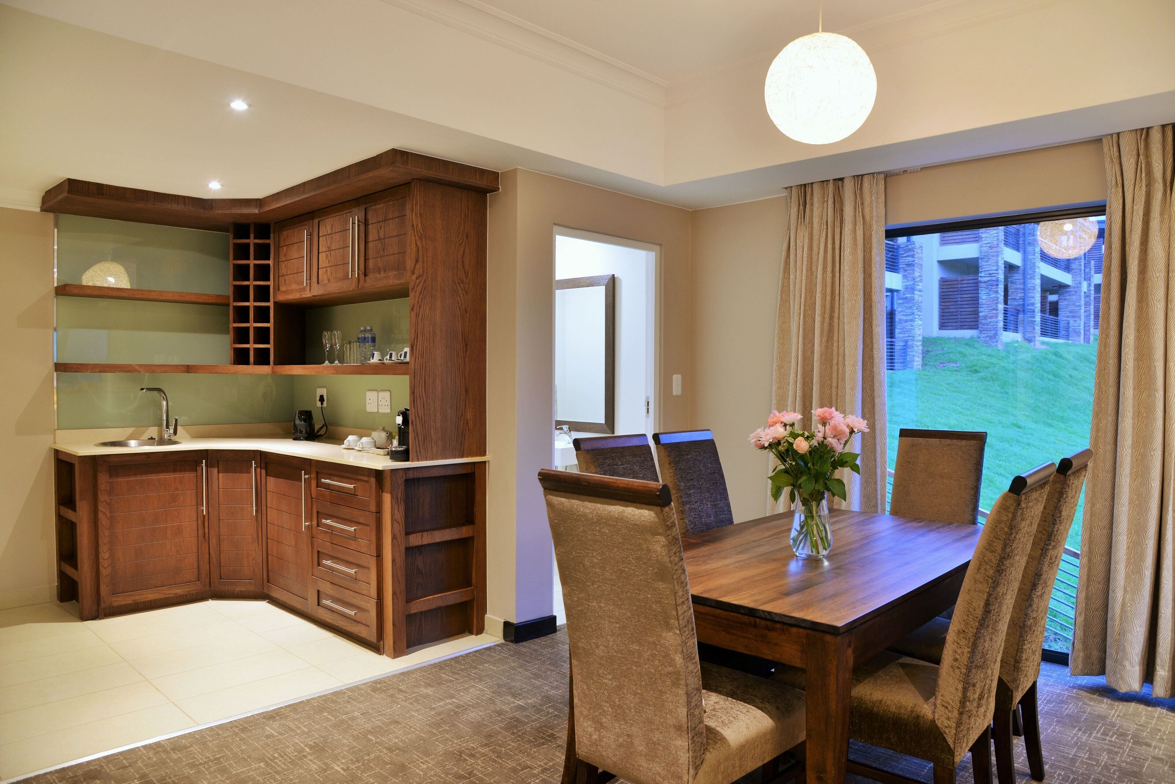 A modern kitchen with wooden cabinets and a dining area with a table and chairs.
