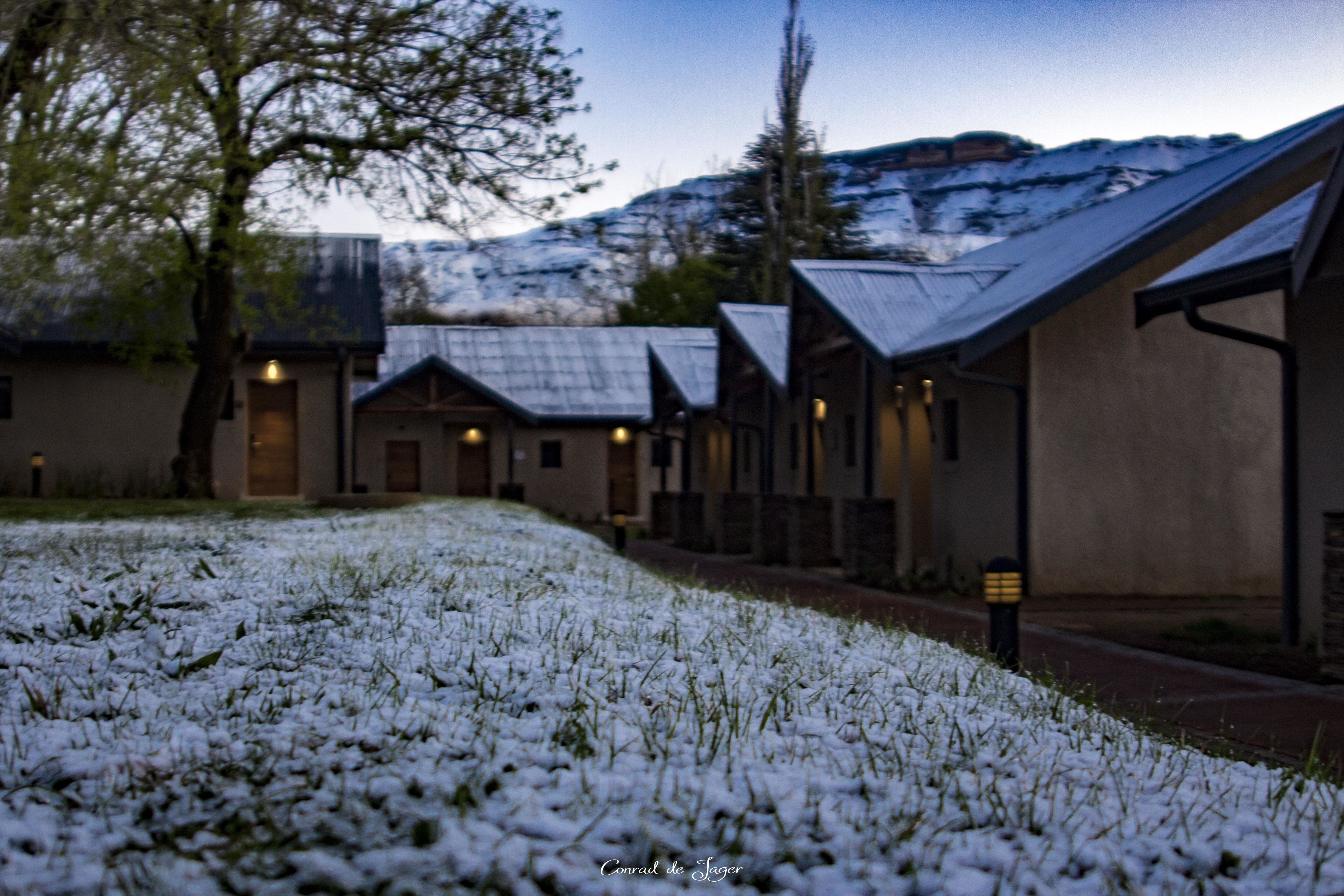 A row of buildings with sloped roofs, likely a hotel or resort, with a snow-covered ground in front.