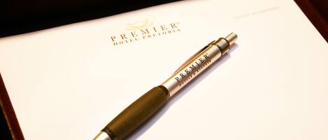 A pen on a white card with the text "PREMIER HOTEL PRETORIA" and "GUEST STATUMERY".
