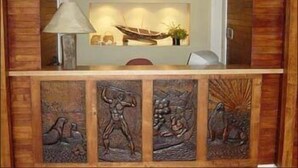 Een receptiebalie met een lamp, een decoratie van een boot en een bord met de tekst 'HOTEL LAKUTIA'.