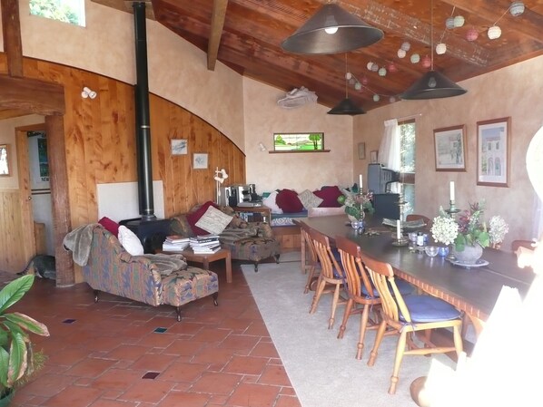 A cozy living area with a sofa, a dining table with chairs, and a kitchen area with a stove.