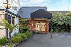 A building with a brick facade, a black awning, and a glass entrance. - Ashford Motor Lodge (Christchurch)