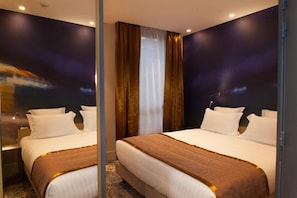 A hotel room with two beds, a large mirror, and a view of the night sky. - Hotel Sixteen Paris Montrouge (Montrouge)