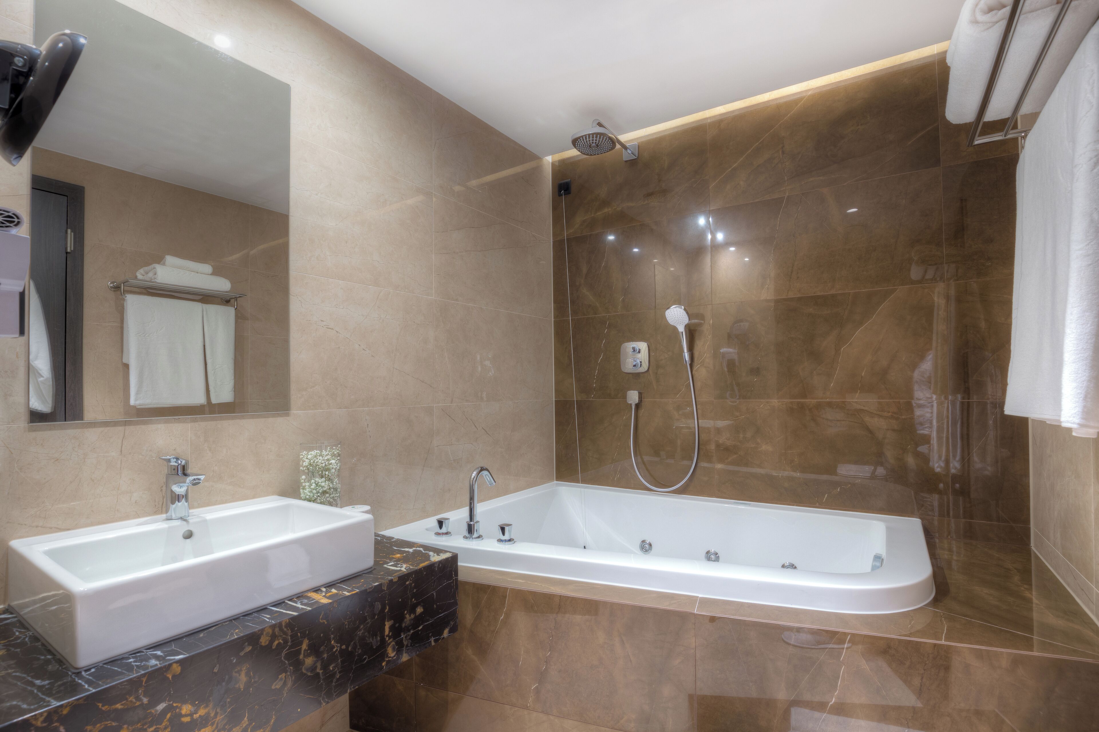 Un baño moderno con lavamanos doble, una bañera grande y una ducha a ras de suelo.