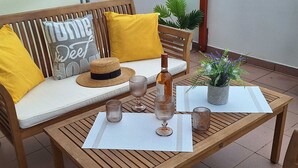 A wooden table with a placemat, a bottle, and glasses. - Apartmani Teo (Hvar)