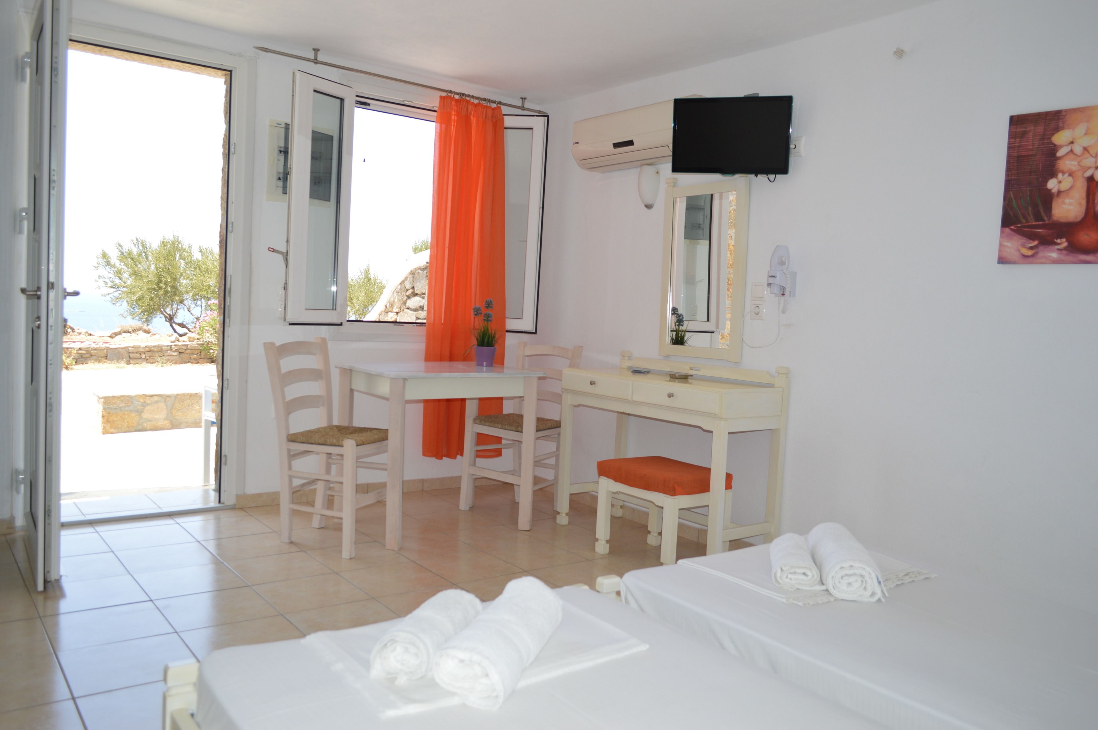 Een hotelkamer met een bed, een bureau, een stoel en uitzicht op de omgeving.