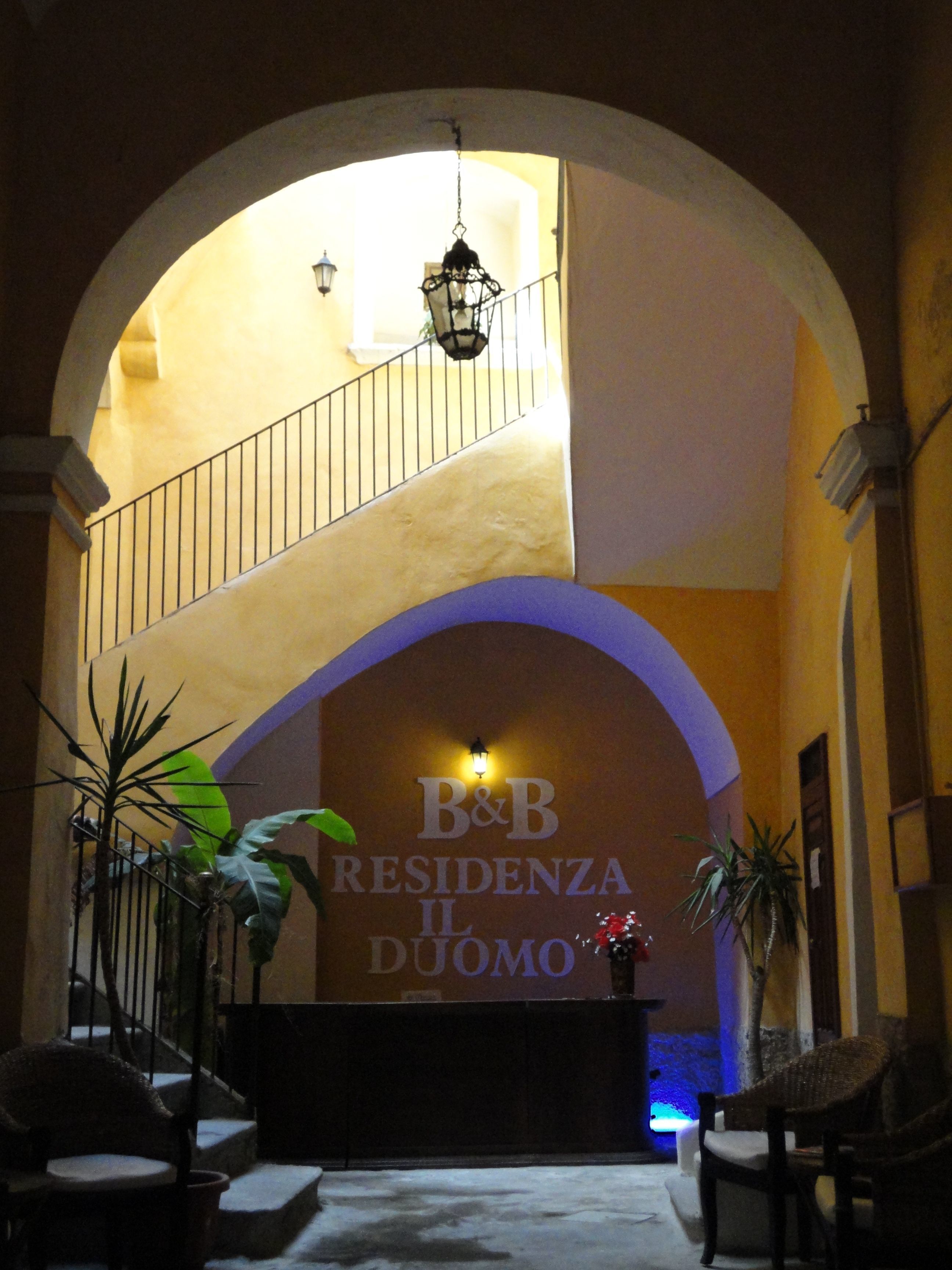 Una entrada arqueada a un hotel con un letrero que dice "B&B RESIDENZA IL DUOMO".