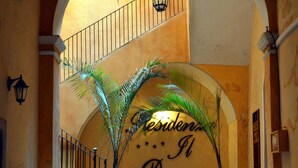 A staircase leading to an upper level with a sign reading "Residencia El Duomo".
