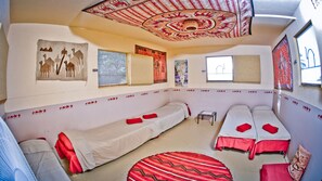 A room with two single beds, a small table, and a window.