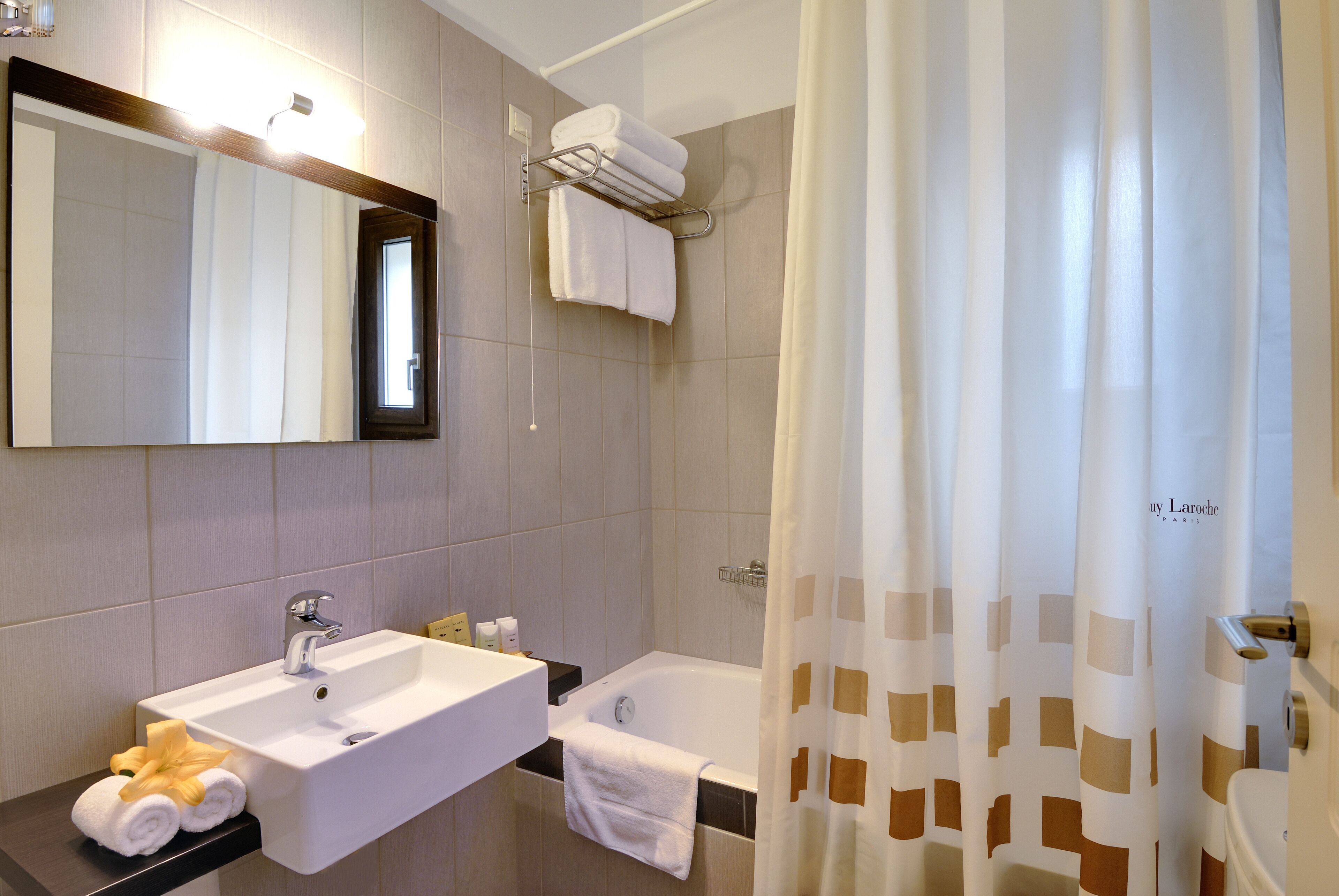 Un baño con lavabo, espejo, toallero y bañera.