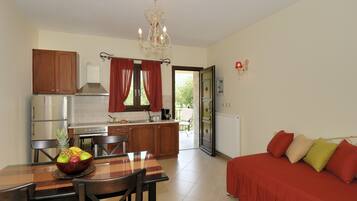 A compact living space with a dining area, kitchenette, and a sofa.