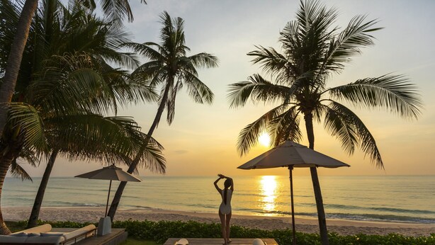 A beachside resort with palm trees, a pool area, and a sunset view. - Cape Nidhra Hotel Hua Hin (Hua Hin)