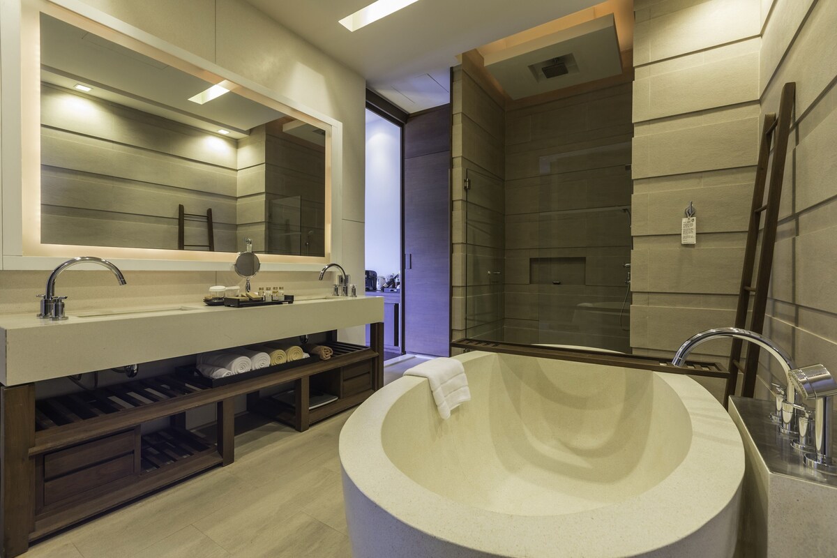 A modern bathroom with a freestanding bathtub, a double sink vanity, and a glass-enclosed shower area.