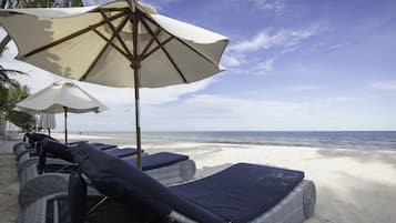 On the beach, white sand, sun-loungers, beach towels