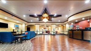 A spacious lobby with a central chandelier, sofas, and a reception desk. - Comfort Suites Lake Worth (Fort Worth)