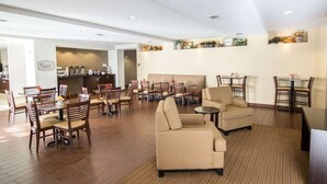 A spacious lobby with multiple seating areas, including sofas and tables, and a coffee station. - Sleep Inn & Suites Norton (Norton)