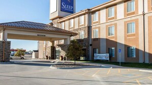 A Sleep Inn & Suites building with a covered entrance, stone facade, and a sign indicating a Platinum Award Winner. - Sleep Inn & Suites Norton (Norton)