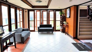 A spacious lobby with a sofa, a desk, and a staircase. - LaOr Inn Hua Hin (Hua Hin)
