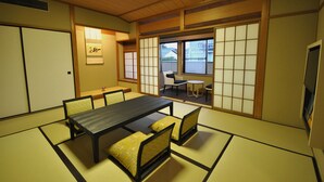 Et traditionelt japansk rum med tatamimåtter, et lavt bord og shoji-skærme.