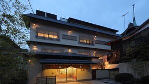 En traditionel japansk bygning med flere etager, et tag med fliser og en port.