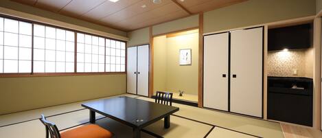 A tatami room with a low table, cushions, and sliding doors.