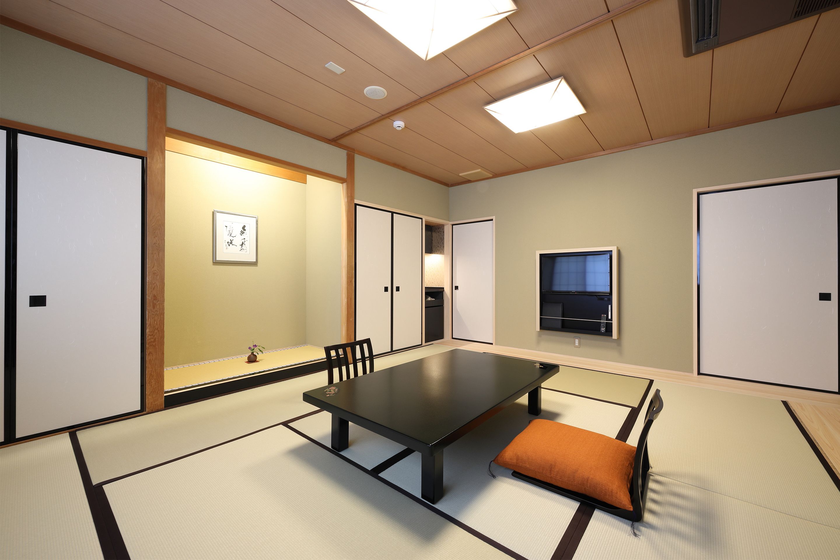 A traditional Japanese-style room with tatami flooring, a low table, and sliding doors.