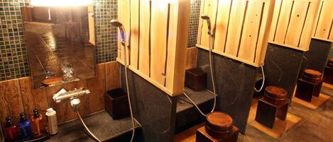 A public restroom with wooden partitions, individual sinks, and a tiled floor.
