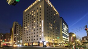 Un hotel de varios pisos con fachada moderna, ventanas iluminadas y señalización destacada que indica que es un hotel.