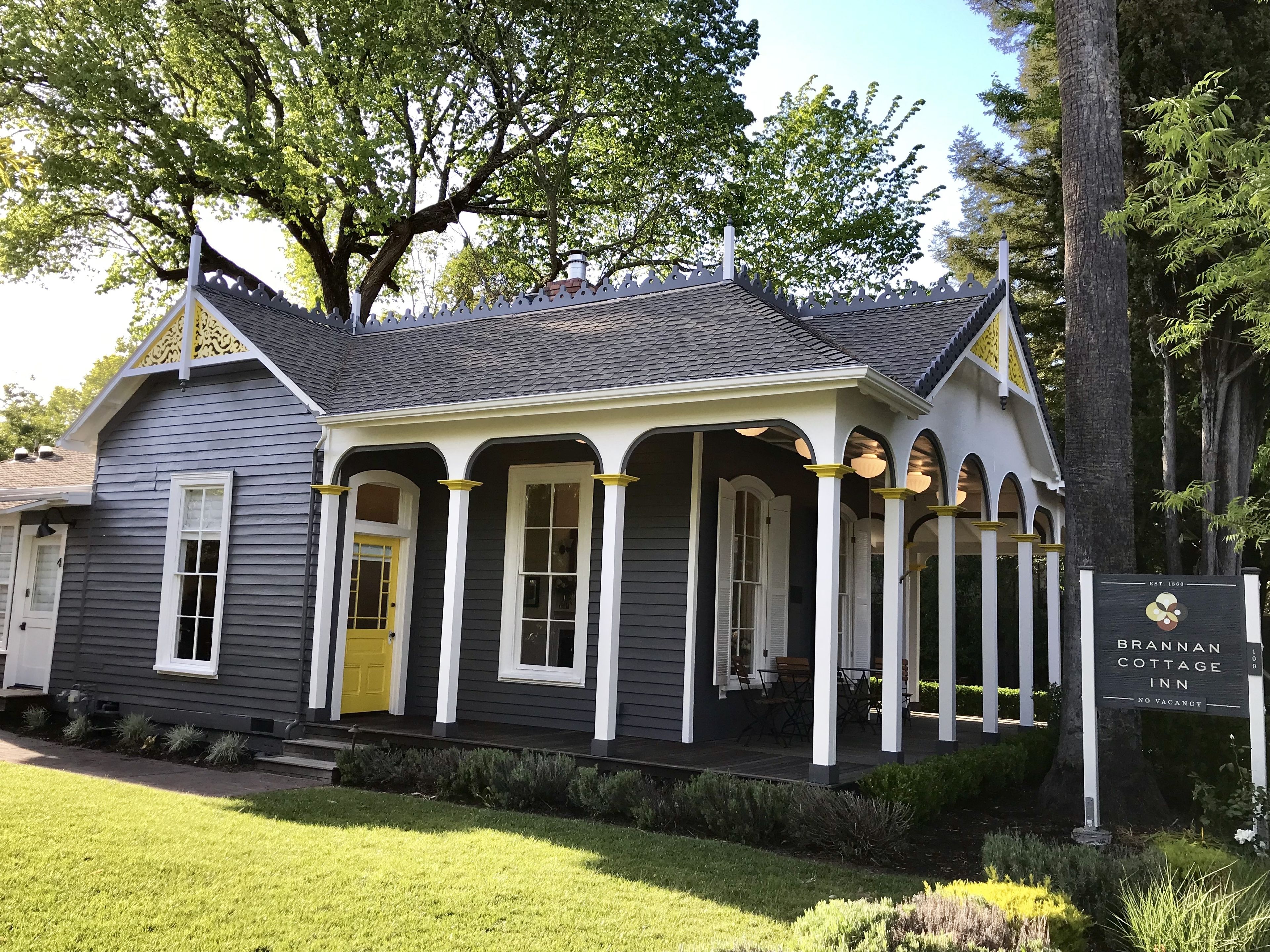 A two-story building with a porch, a yellow door, and a sign indicating it is the Brannan Cottage Inn.