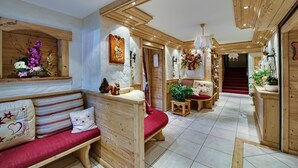 Un interior de madera con un banco, una mesita y una escalera que conduce a otra habitación.
