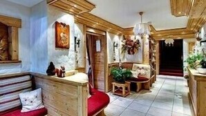 Un interior de madera con un banco, una mesita y una silla.