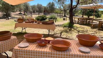 An outdoor dining area with checkered tablecloths and terracotta bowls.