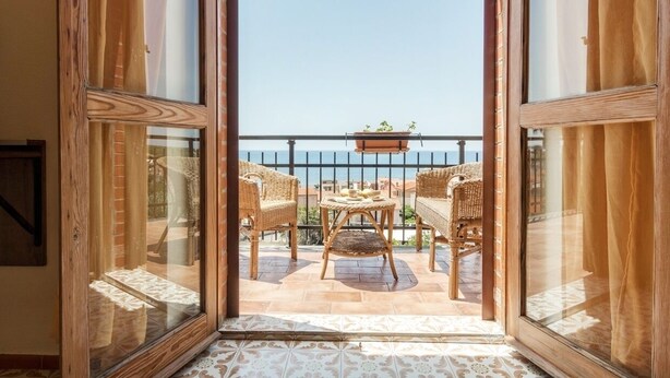 A balcony with wicker furniture and a view of the sea. - Mare Lughente (Cuglieri)
