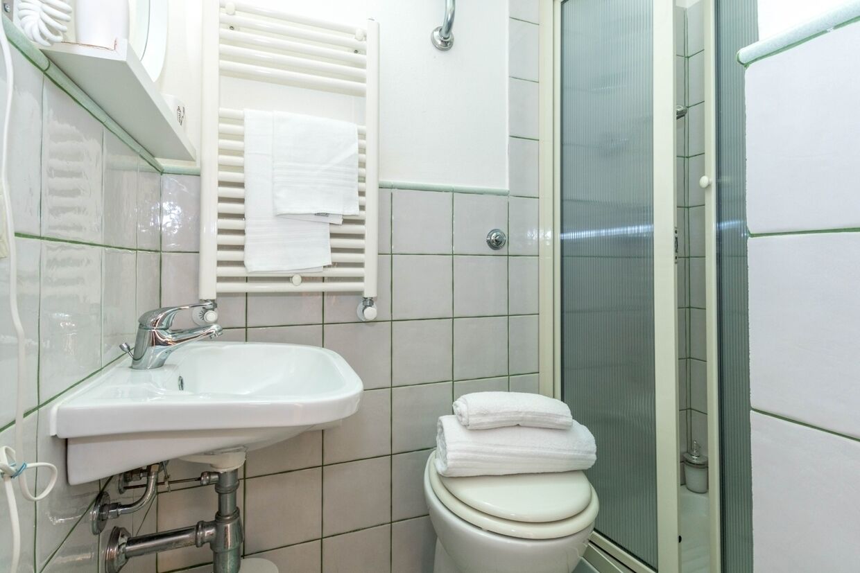 Ein Badezimmer mit Waschbecken, Toilette und Duschkabine aus Glas.