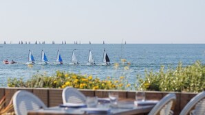 A seaside restaurant with outdoor seating overlooking the sea. - Logis Hôtel & Restaurant Les Mouettes - Larmor Plage, proche de Lorient (Larmor-Plage)