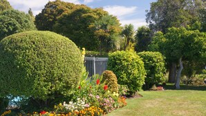 A well-maintained garden with various flowering plants and neatly trimmed hedges. - Middle Park Motel (Blenheim)