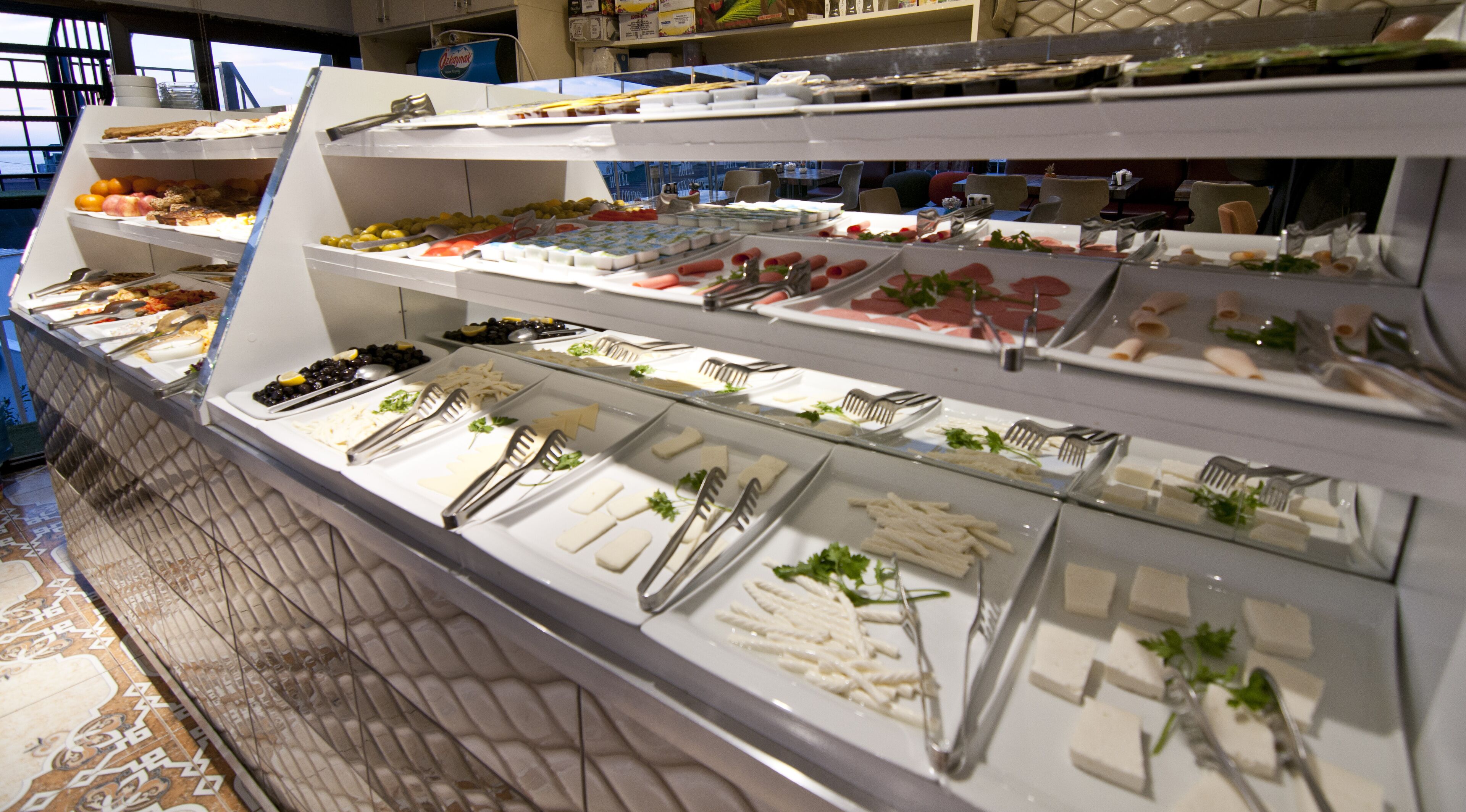 A buffet with various food items and utensils.