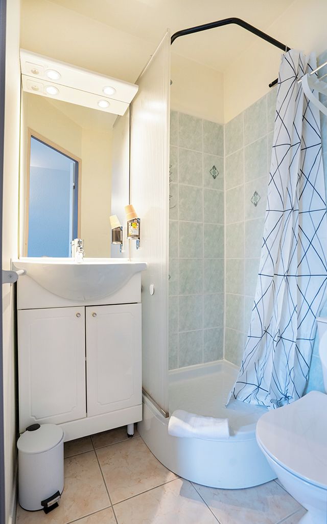 A bathroom with a shower, sink, and toilet.