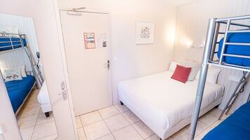 A room with bunk beds, a door with a calendar, and a framed picture on the wall.