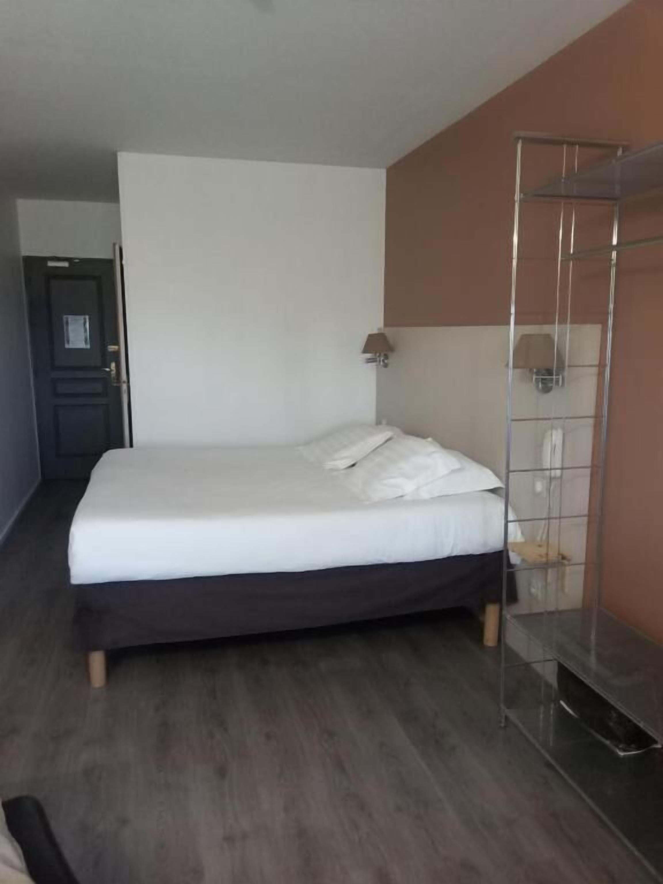 Un dormitorio con una cama, un armario y una puerta.