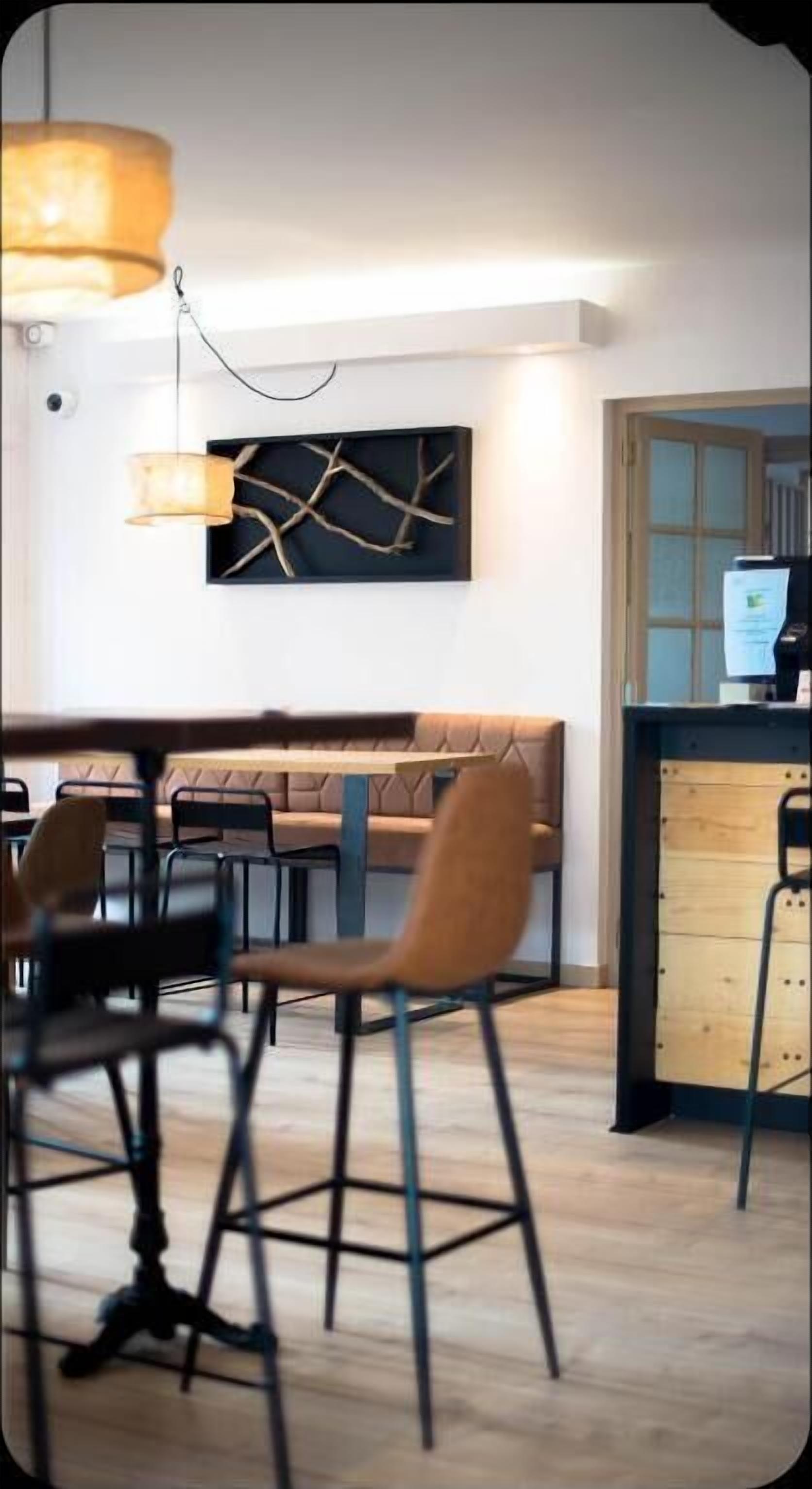 A modern dining area with a wooden bench, metal chairs, and a pendant light.