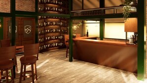 A bar area with a brick wall, wooden chairs, and a counter with a hanging plant. - Valle Andino  (Uspallata)