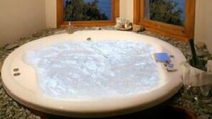 A hot tub with a view of the sea through two windows. - La Sirenuse Lake Resort (San Carlos de Bariloche)