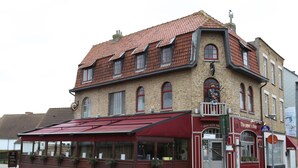 A two-story building with a red awning and a sign that reads "The Piper's Dutch." - The Piper's Pub (Middelkerke)