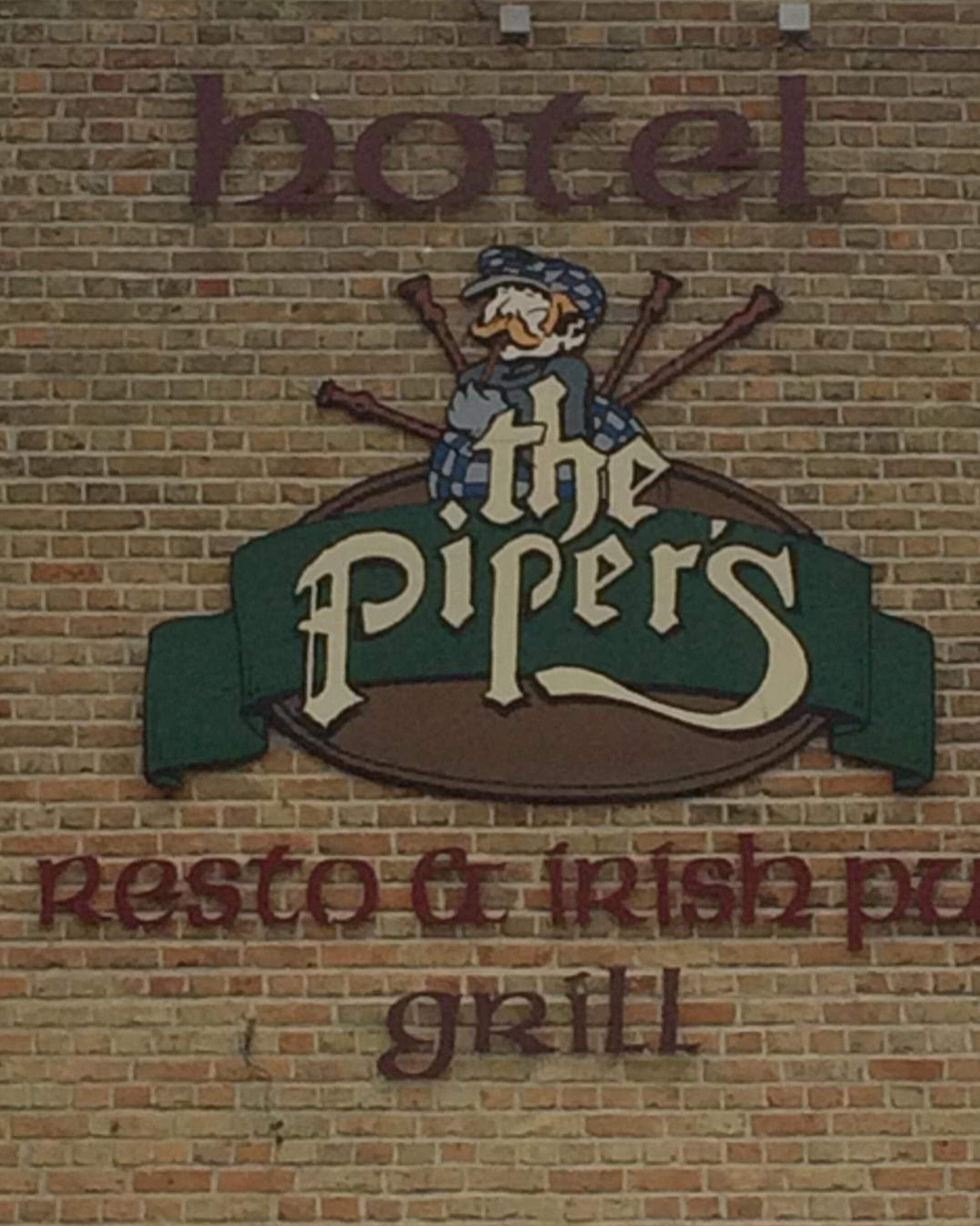 Letrero de 'The Piper's' con un logotipo que muestra un personaje y las palabras 'hotel, restaurante, pub irlandés y parrilla'.